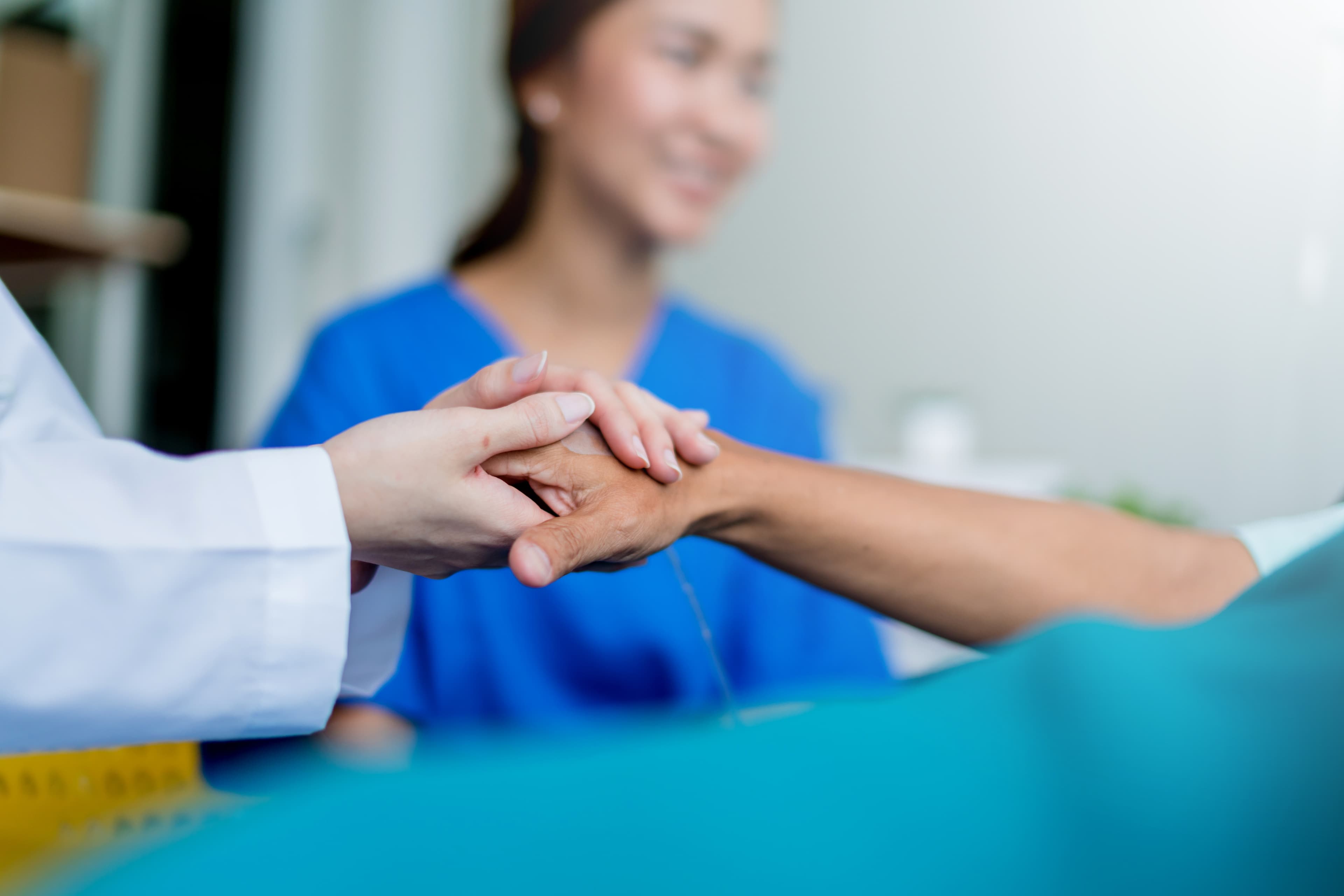 Doctor holding a patient's hands in reassurance